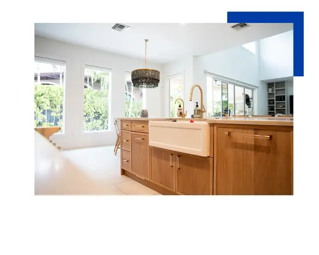 Kitchen with wood island, white farmhouse sink, beaded pendant light and tall windows